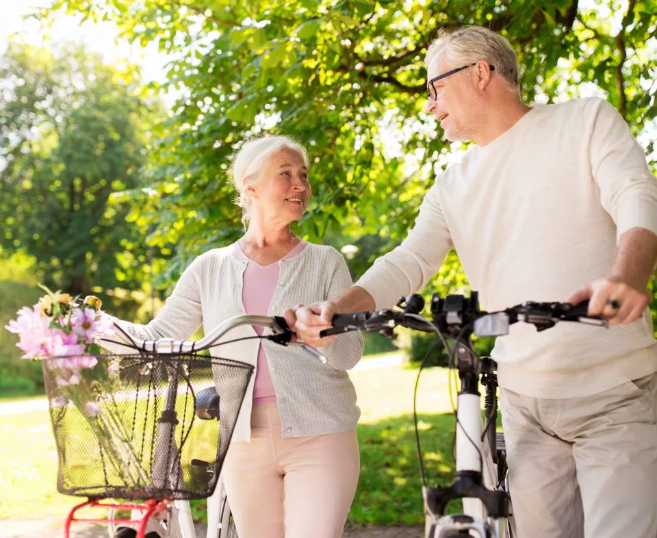 happy senior couple with bicycles at summer park